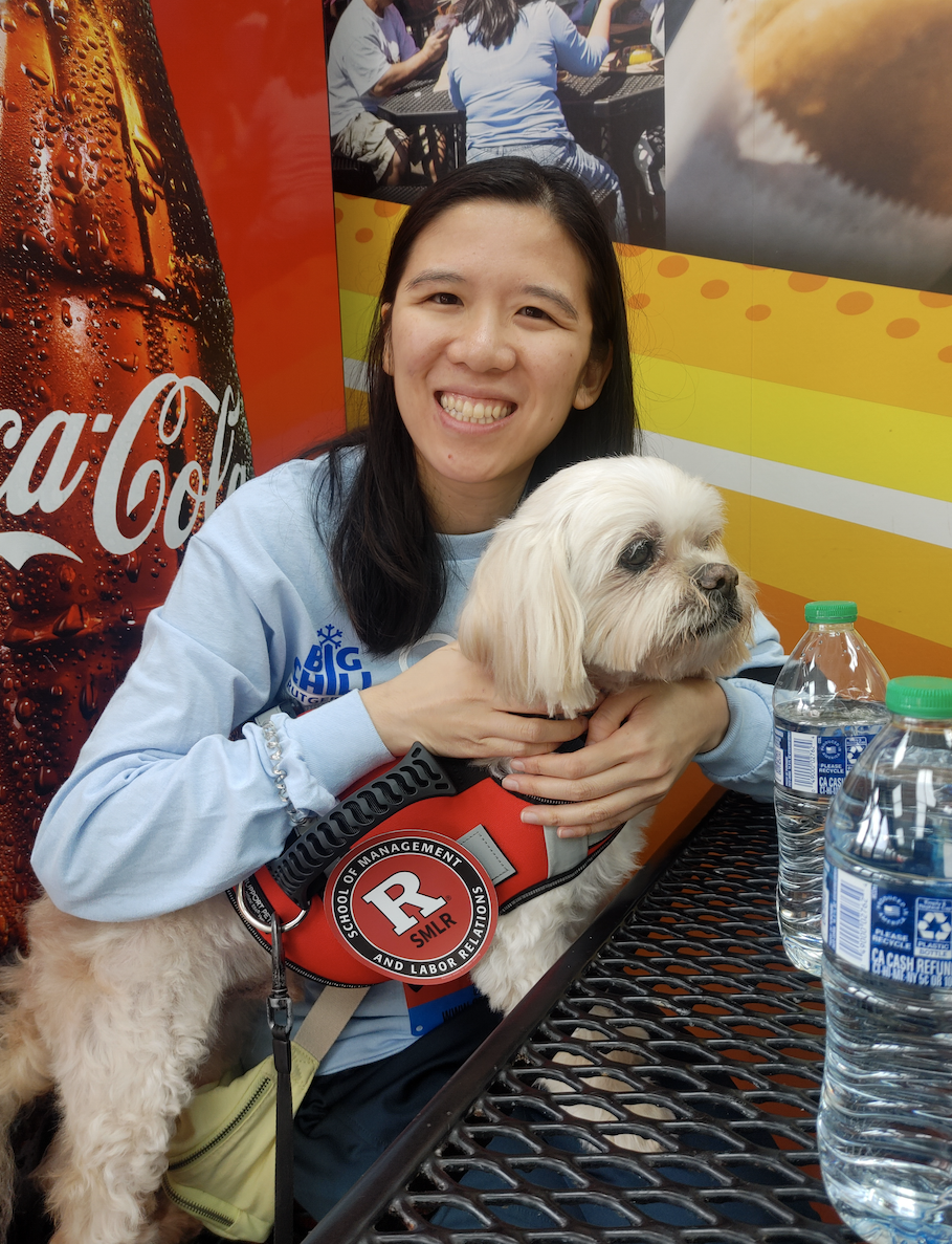 Image of Alumni Tracy Ng posing with a dog
