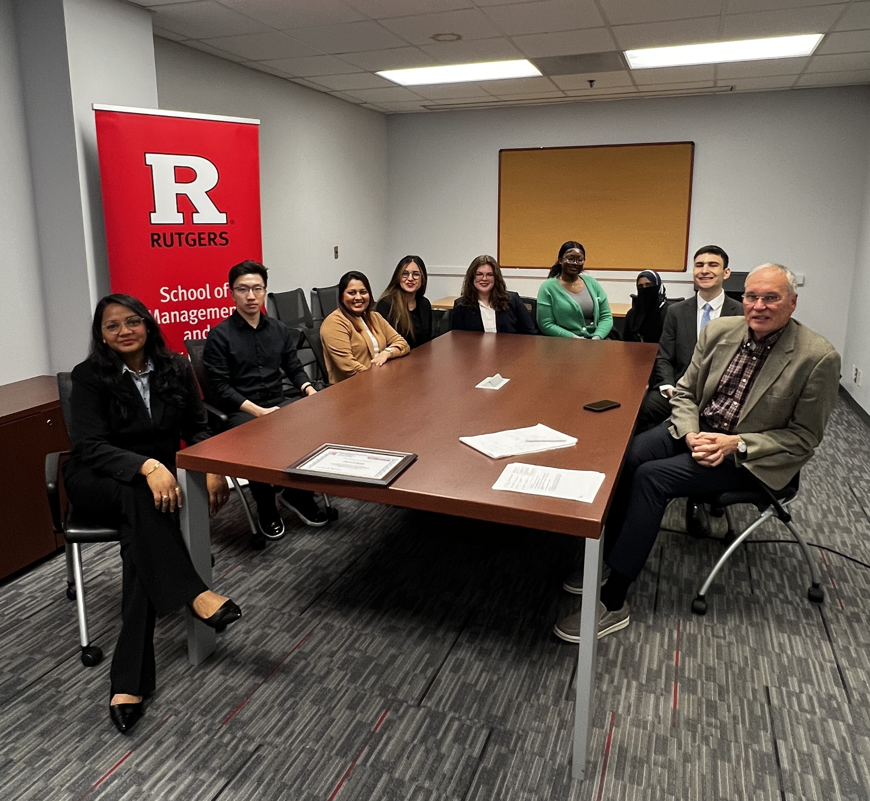 Image of students sitting around a table with Professor David Ferio at the 2025 Internal Case Competition
